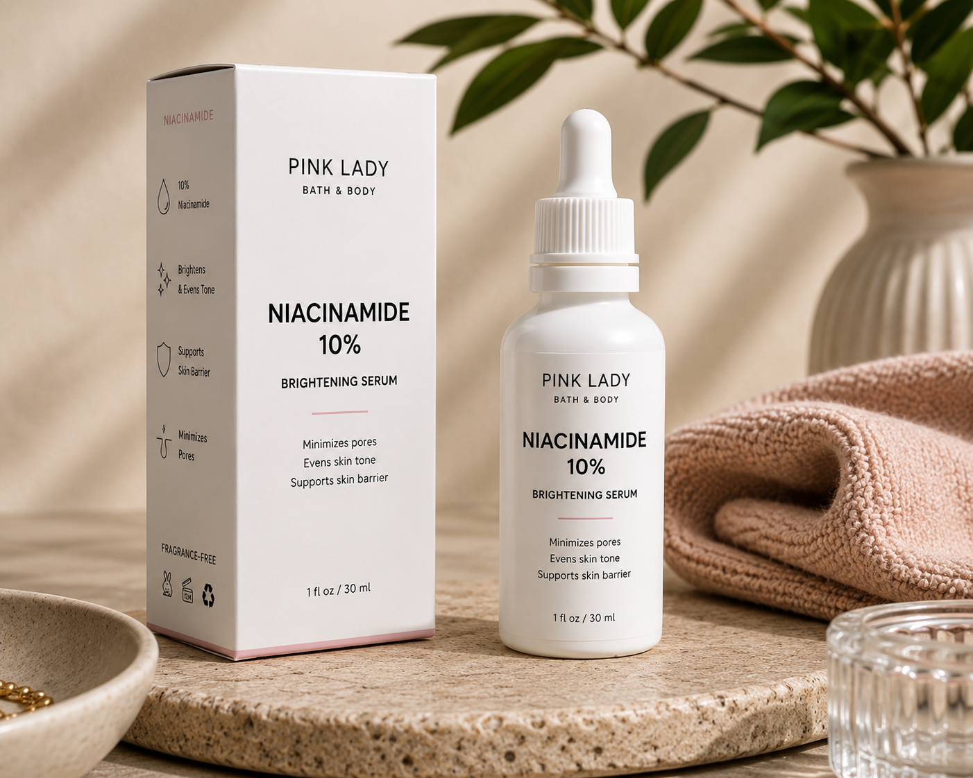Pink Lady Bath & Body Niacinamide 10% Brightening Serum in a white dropper bottle with matching box on a warm neutral stone surface.