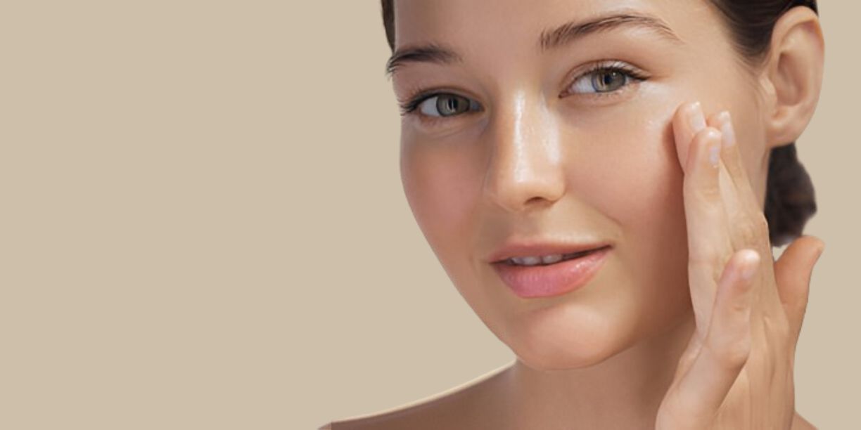 Woman applying product to her cheek, highlighting glowing, healthy skin, showing the moisturizing benefits of Pink Lady Bath and Body handmade soaps.