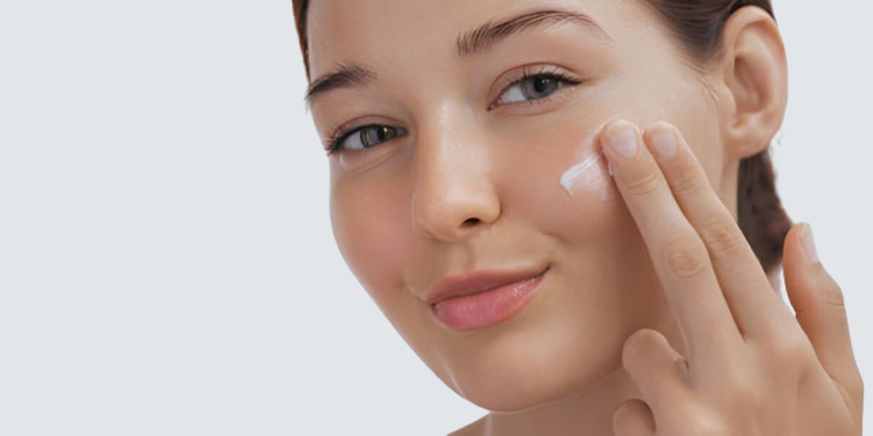 Woman applying product to her cheek, highlighting glowing, healthy skin, showing the moisturizing benefits of Pink Lady Bath and Body handmade soaps.